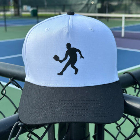 White and black cap with a tennis player silhouette on a tennis court background